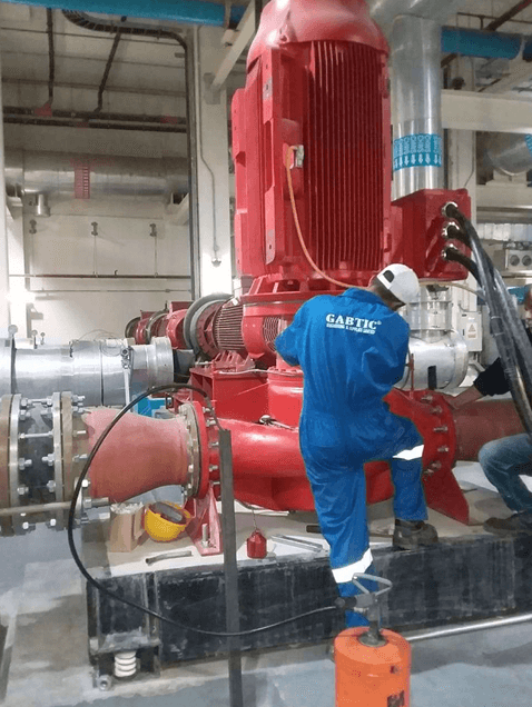 GABTIC technician installing a large red vertical inline pump